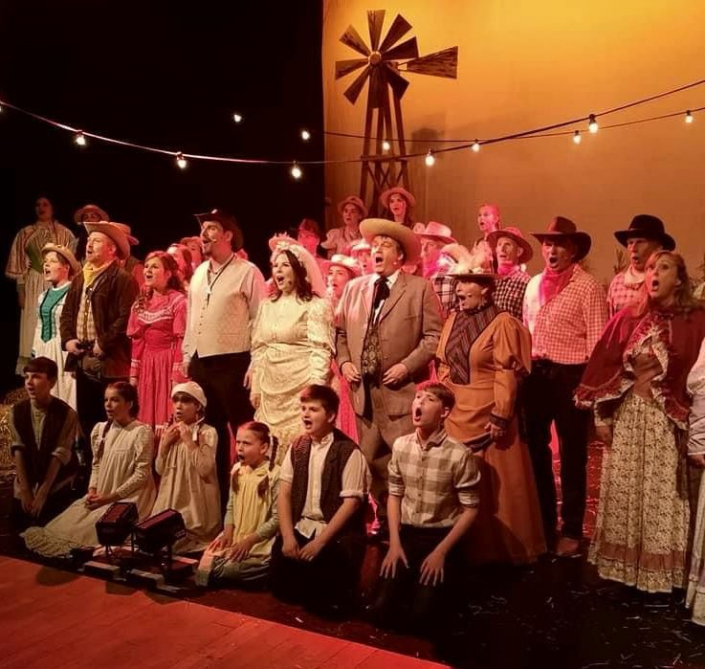 the full cast of Oklahoma! on stage