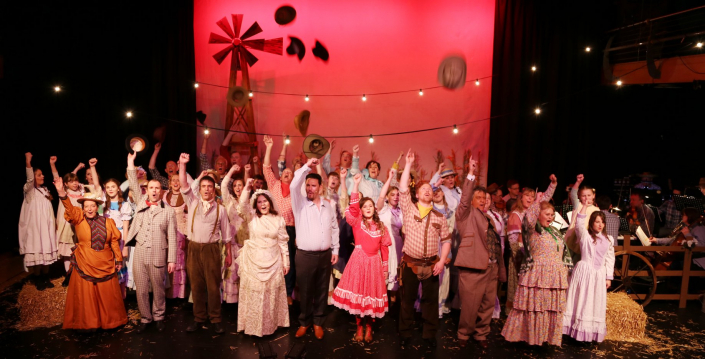 the full cast of Oklahoma! on stage