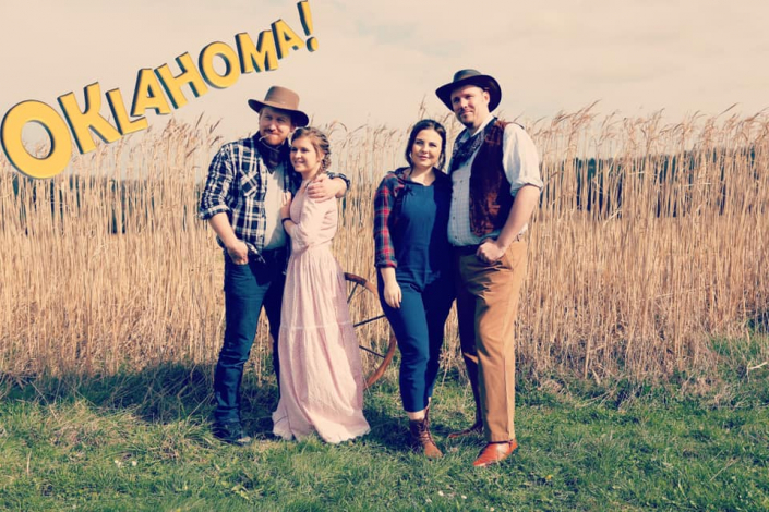 publicity photo for Oklahoma! taken in a field of corn, featuring Laurey, Curly, Ado Annie & Will Parker