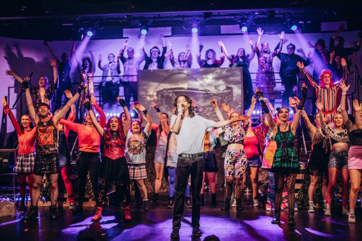 the full cast of "We Will Rock You" photographed live on stage