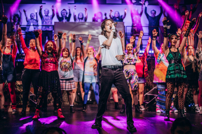 the full cast of "We Will Rock You" photographed live on stage